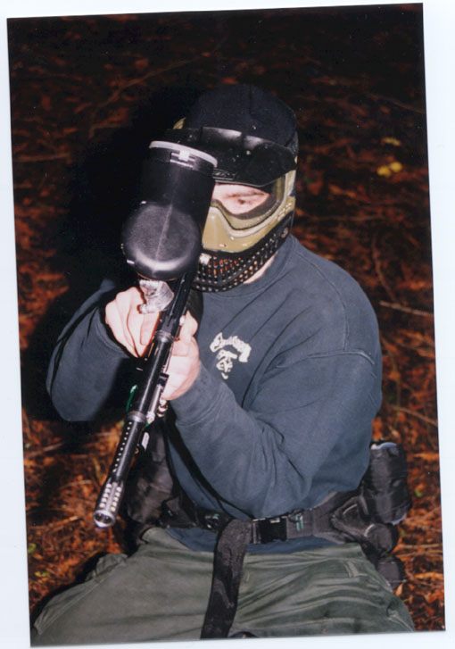 Paintball player in protective gear photographed on the field.