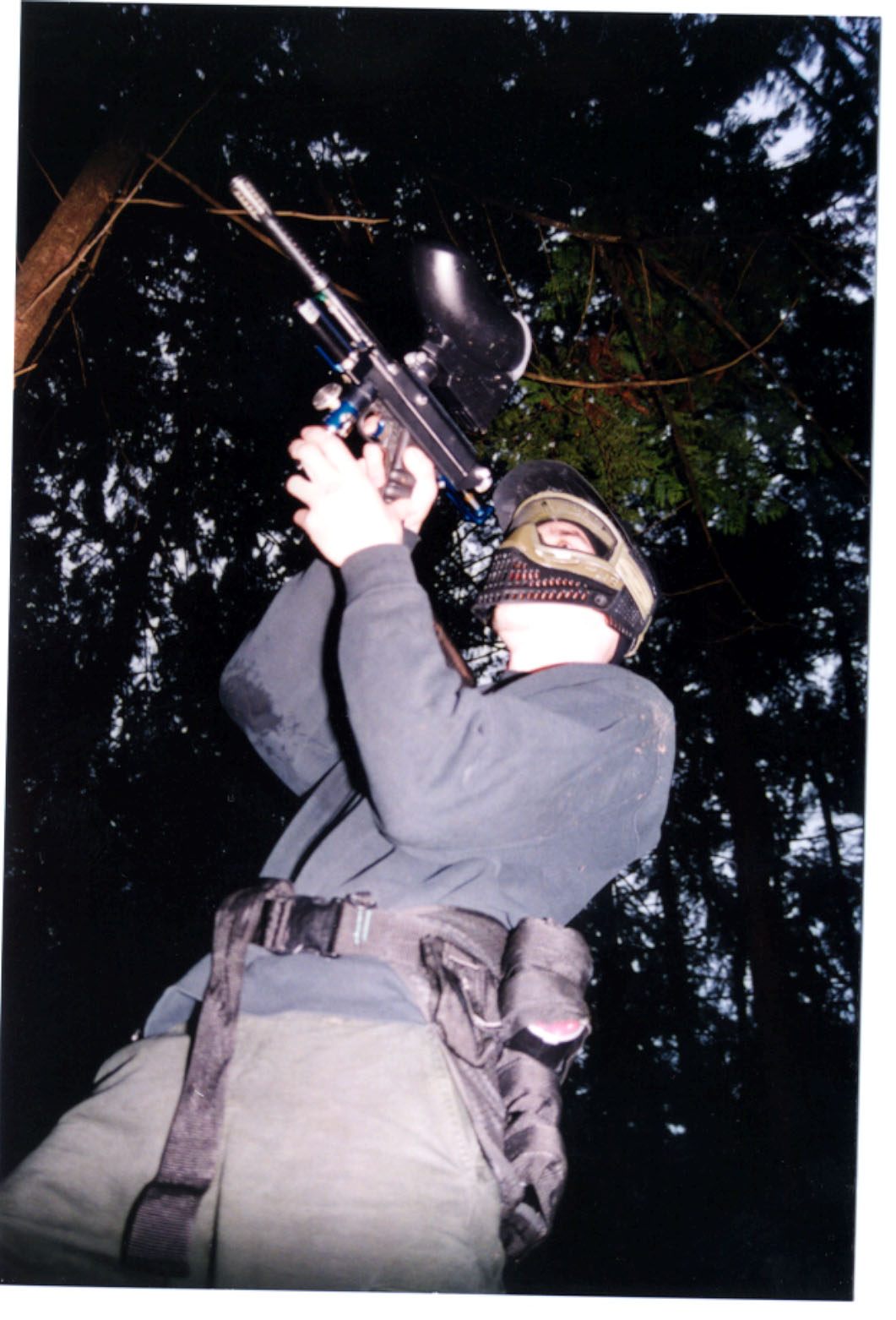Paintball player photographed in action on the field, portrait framing.