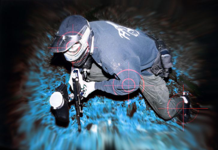 Wide landscape action photograph of a paintball player on the field.